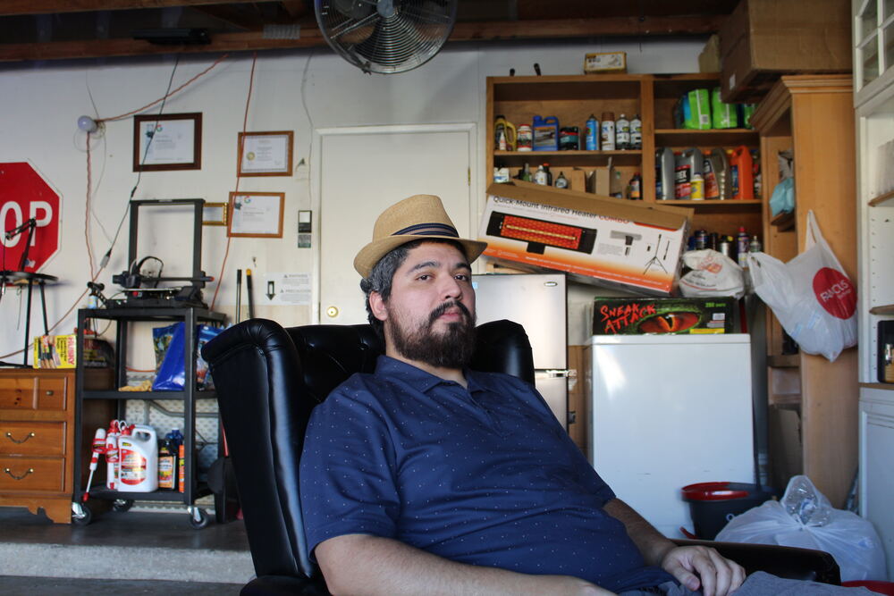 Diege A. Gator Verdin Diaz seated in a chair wearing a straw hat